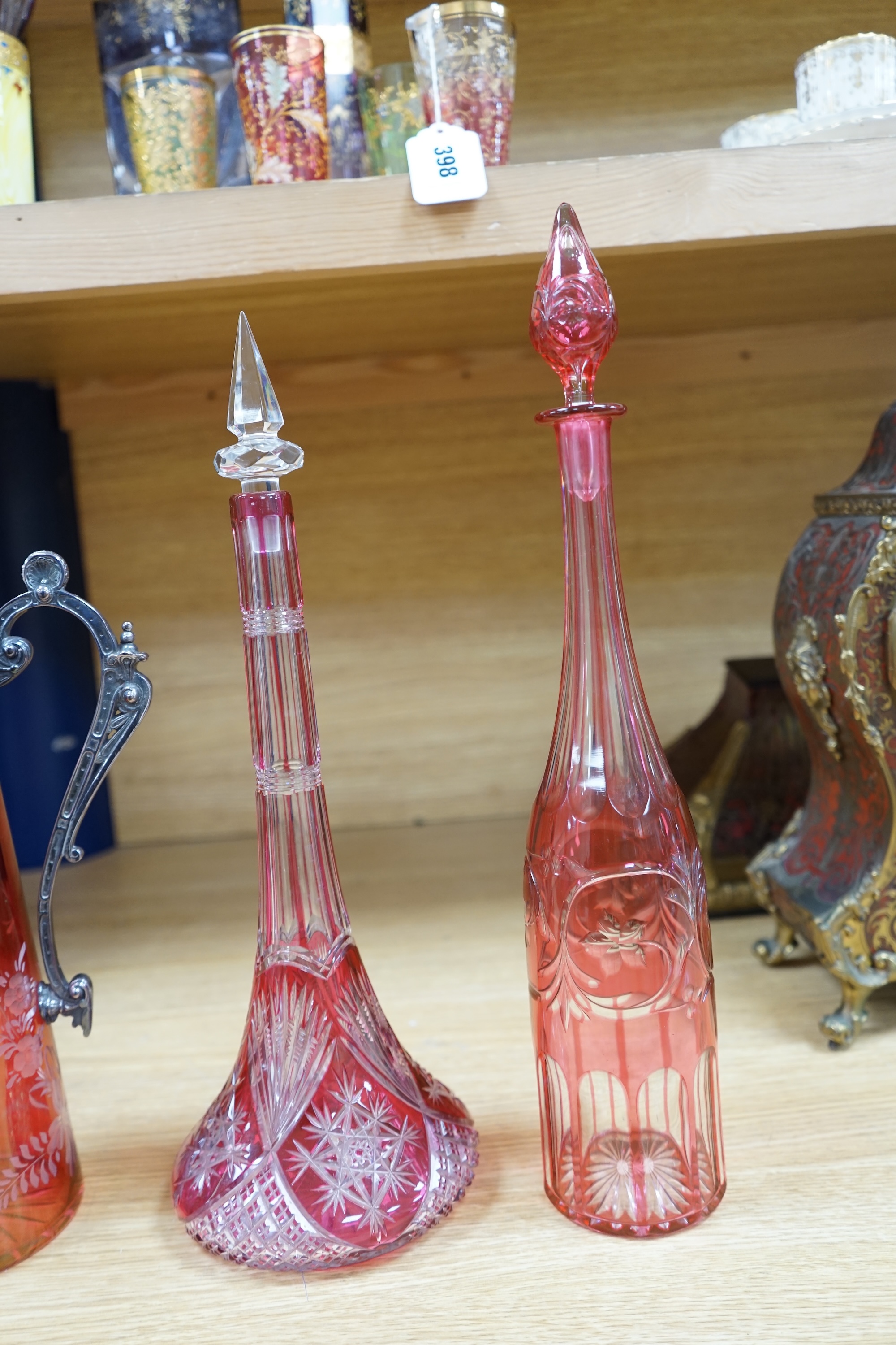 A collection of cranberry glassware comprising three decanters with stoppers and a silver plate mounted ewer, largest 41cm high. Condition - fair to good